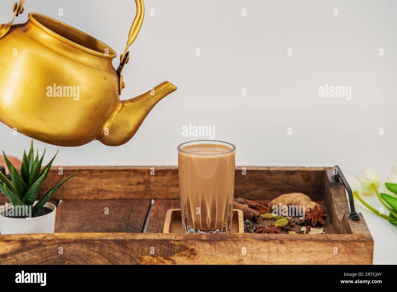 Tè indiano masala chai. Tè speziato Masala chai con latte e spezie o karak chai o taglio chai. Il tè viene versato nei bicchieri da un bollitore. Foto Stock
