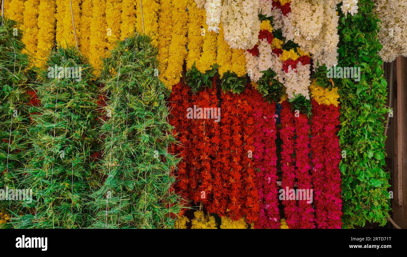 Scatto di una serie di ghirlande di fiori appese a un negozio di fiori. Foto Stock