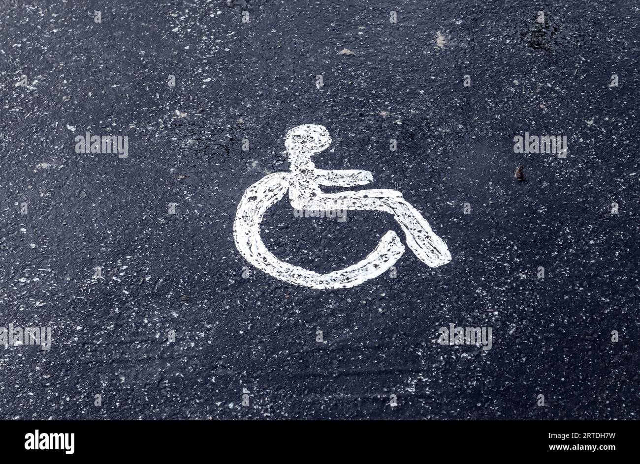 Parcheggio con insegna dipinta di sedia a rotelle. Posti auto per disabili. Foto Stock