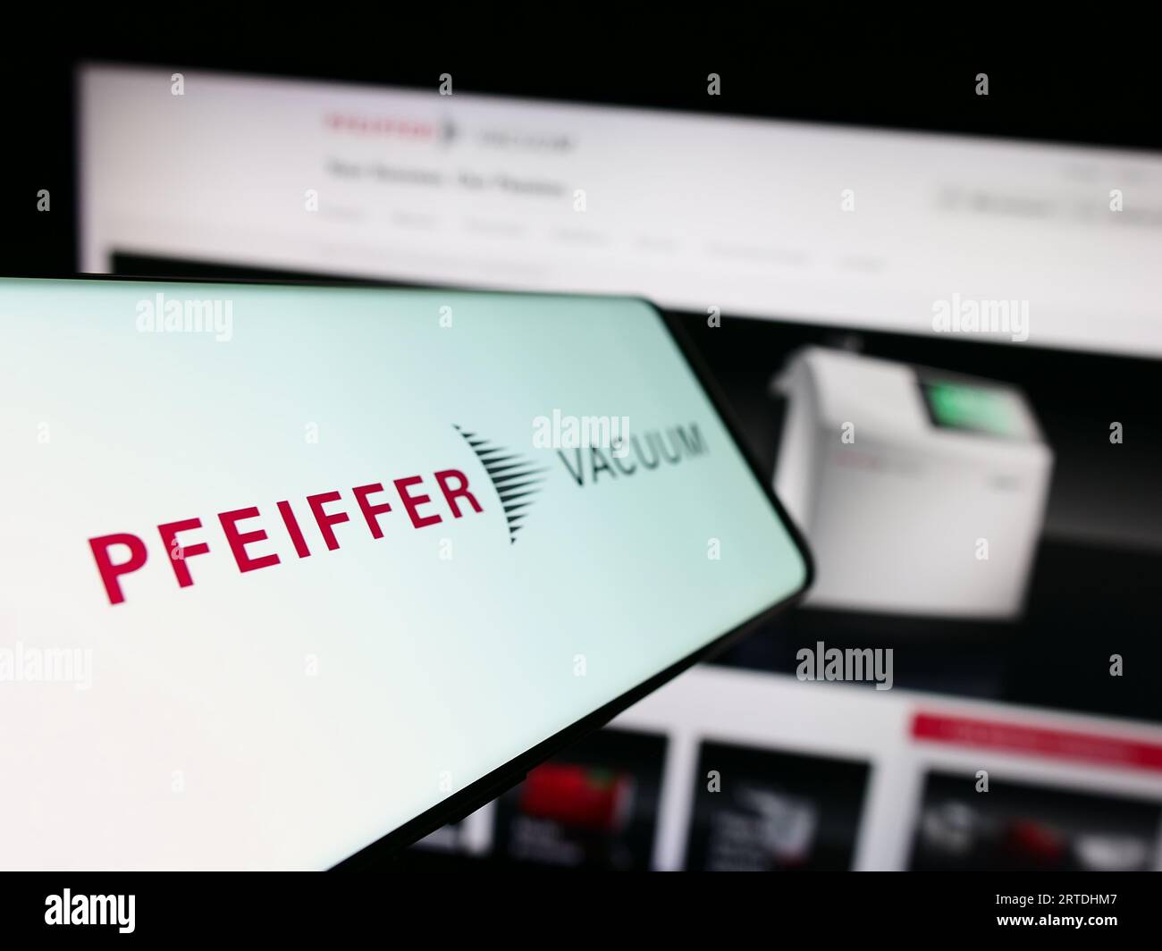 Smartphone con logo della società tedesca Pfeiffer Vacuum Technology AG sullo schermo davanti al sito Web. Mettere a fuoco il display centrale sinistro del telefono. Foto Stock