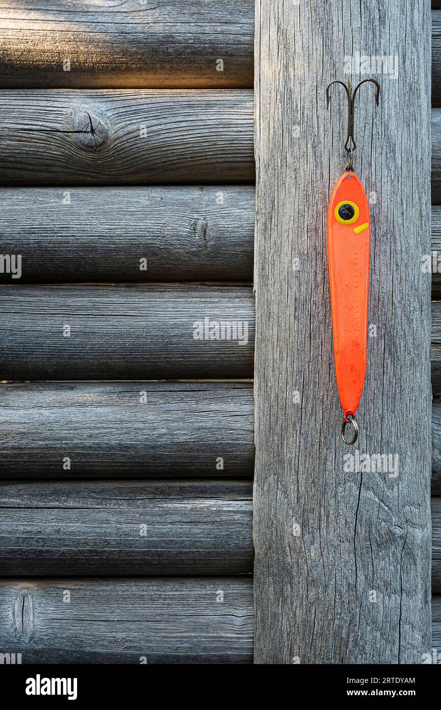 un grande attrezzo da pesca rosso che si erge su una recinzione grigia intemprata Foto Stock