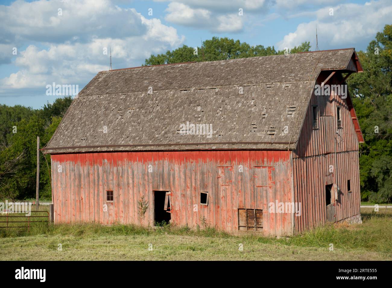 Fienile abbandonato con facciata intemprata e vernice rossa sbiadita, vicino a Dunbar, Nebraska, USA; Dunbar, Nebraska, Stati Uniti d'America Foto Stock