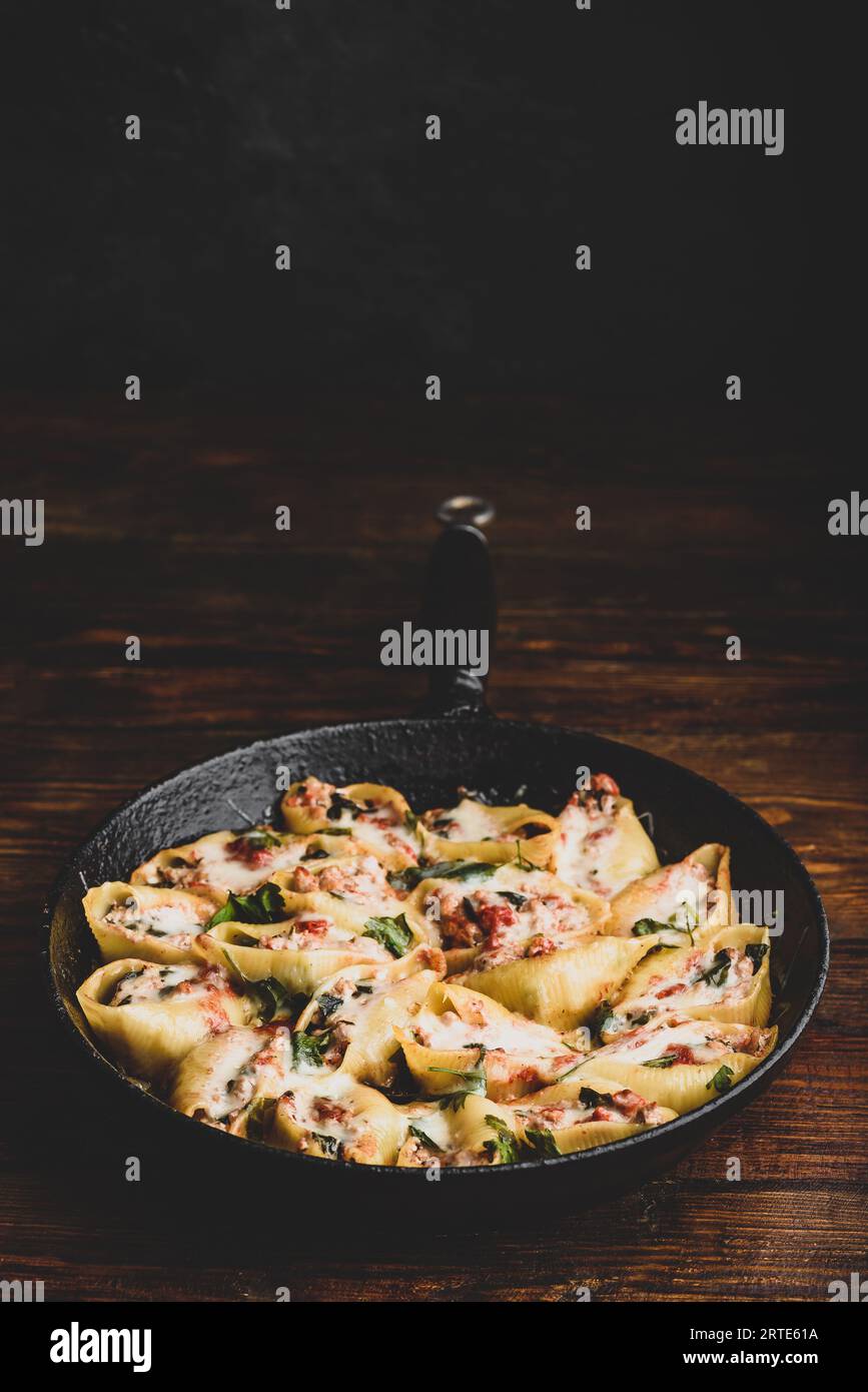 Pailletto di conchiglie di jumbo al forno farcite con manzo macinato, spinaci e formaggio Foto Stock