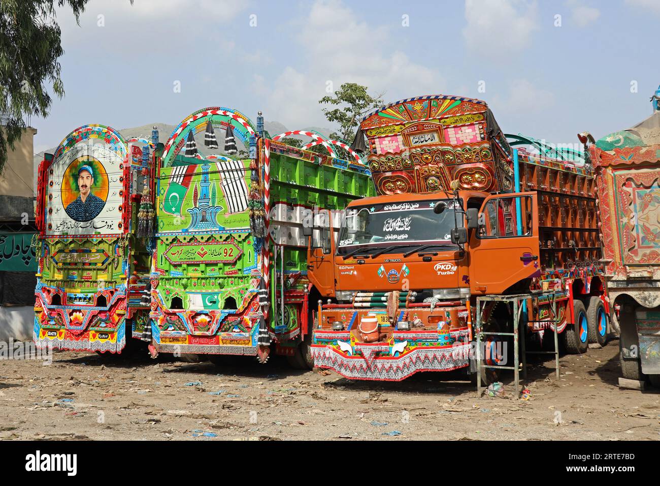 Camion pakistani parcheggiati fuori da un laboratorio di pittura Foto Stock