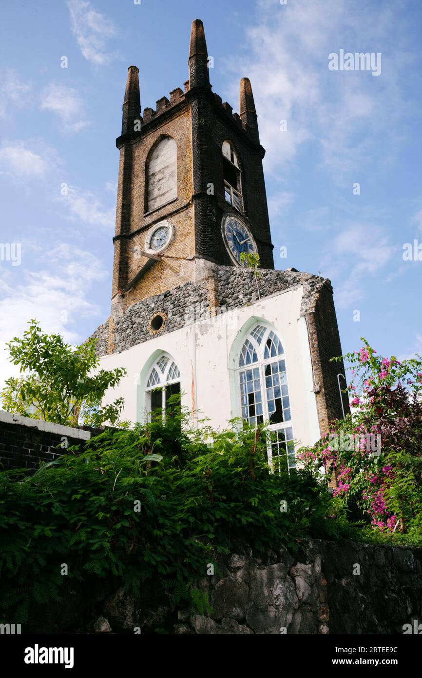 Vista ravvicinata della torre dell'orologio e del muro di pietra con finestre su un cielo blu, i resti della chiesa presbiteriana di Sant'Andrea (che era pesantemente... Foto Stock