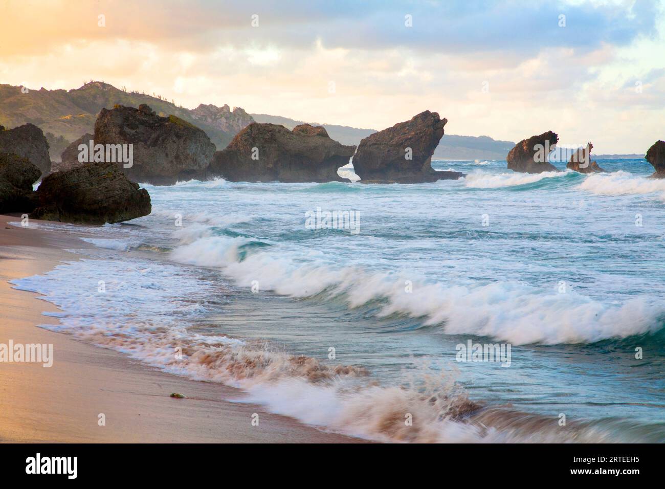 Vista panoramica delle piene di mare con grandi onde, onde oceaniche che si infrangono contro le rocce della spiaggia di Bathsheba al crepuscolo Foto Stock
