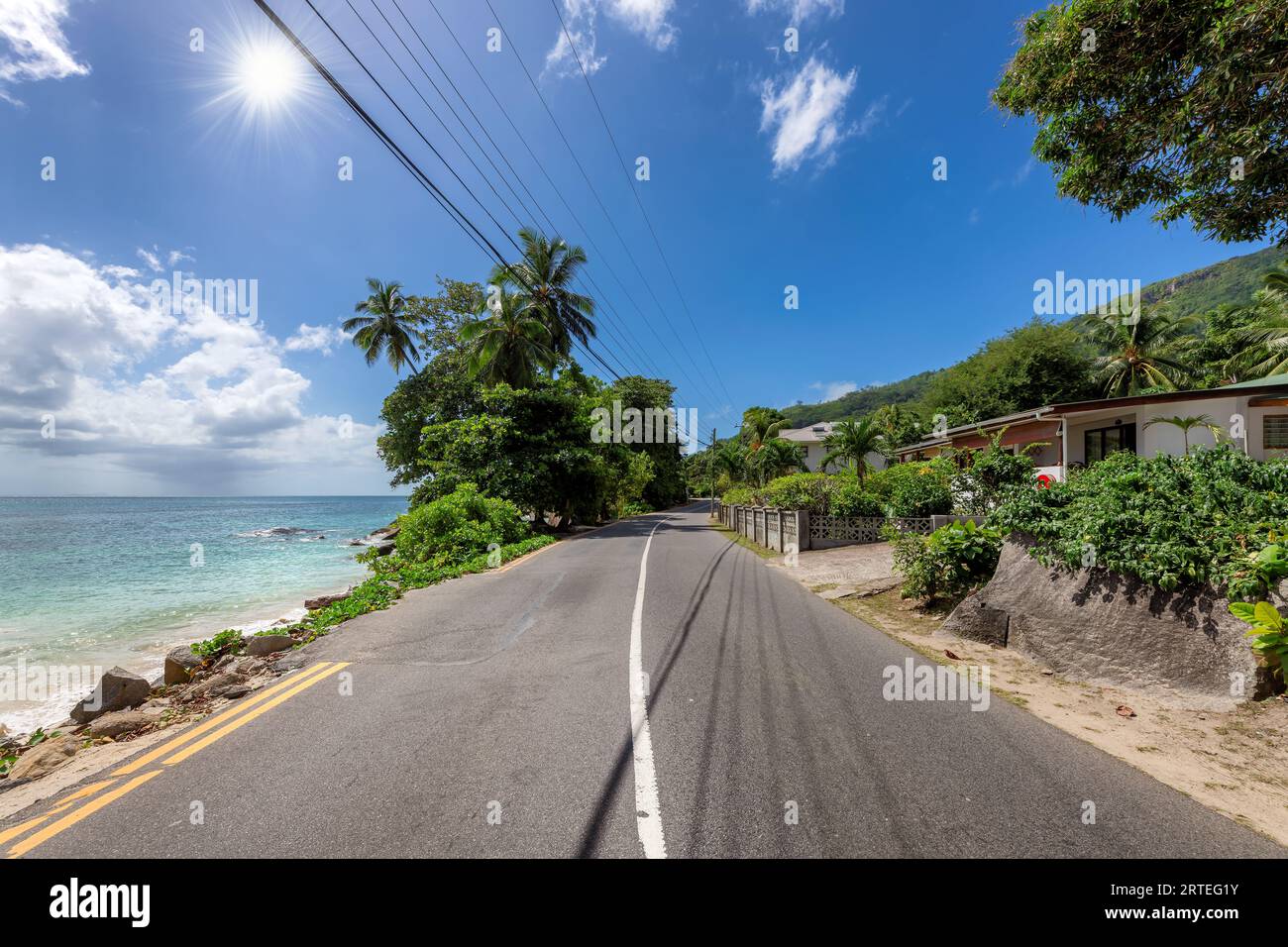 Scenografica e soleggiata strada sulla spiaggia nell'isola tropicale delle Seychelles Foto Stock