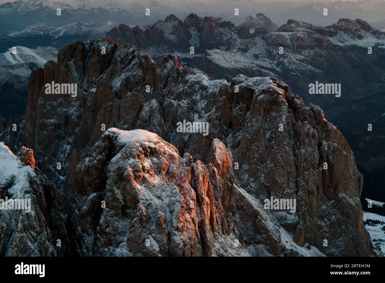 La luce del sole bacia una vetta spolverata di neve nelle Dolomiti; Ortisei, Italia Foto Stock