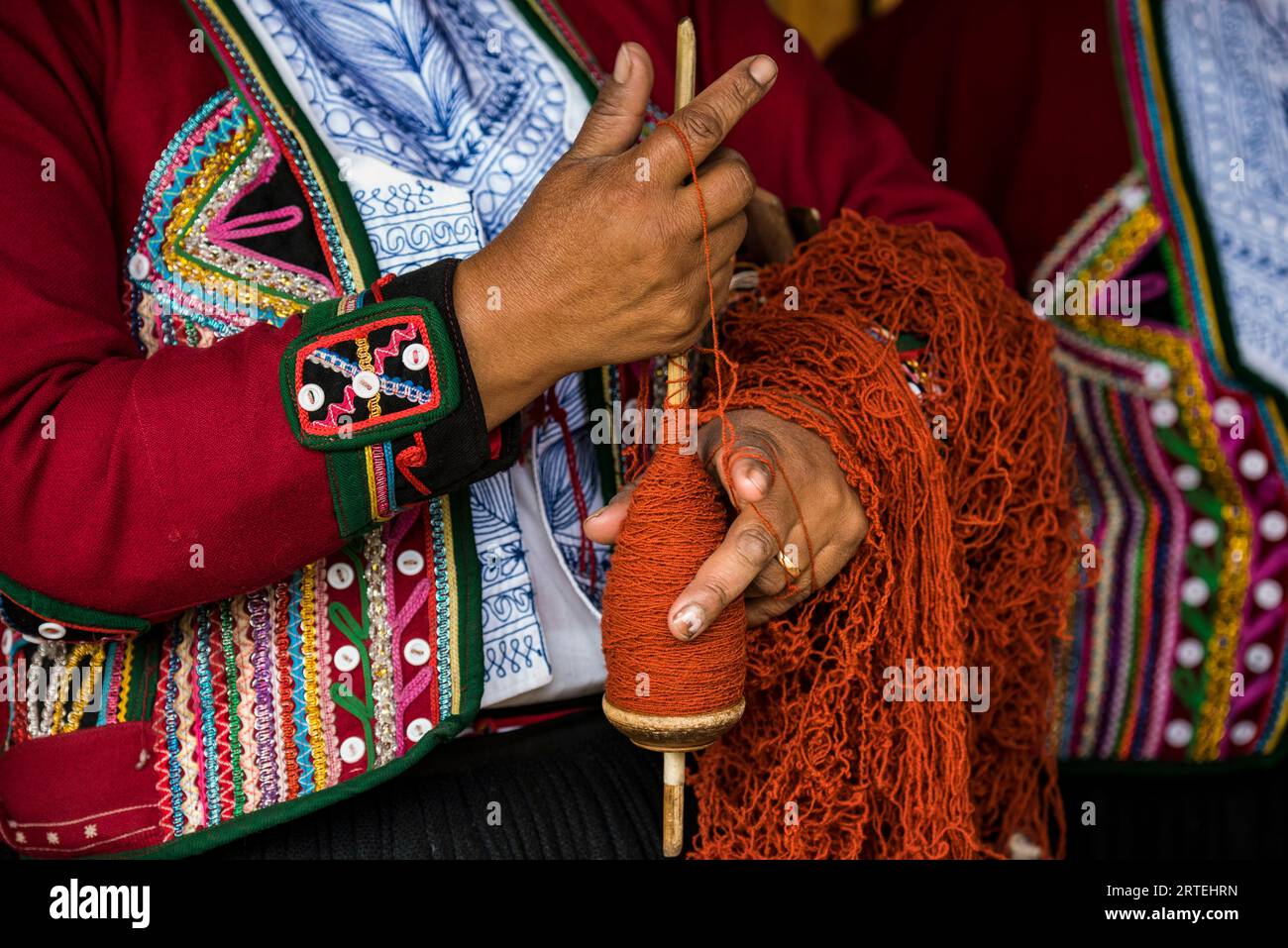 Le donne quechuan di Chinchero tessono abiti tradizionali in modi tradizionali per la vendita; Cusco, Perù Foto Stock