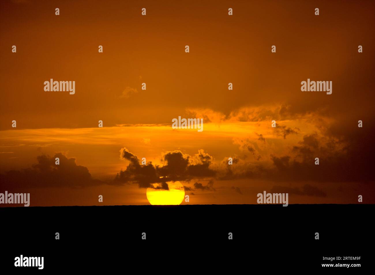 Sole dorato brillante che tramonta sul Mar dei Caraibi, Tobago; Pigeon Point, Tobago, Repubblica di Trinidad e Tobago Foto Stock