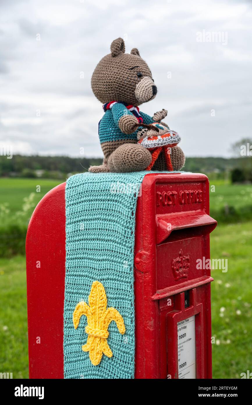 Orsetto all'uncinetto e simbolo scout su una cassetta postale reale del Regno Unito Foto Stock
