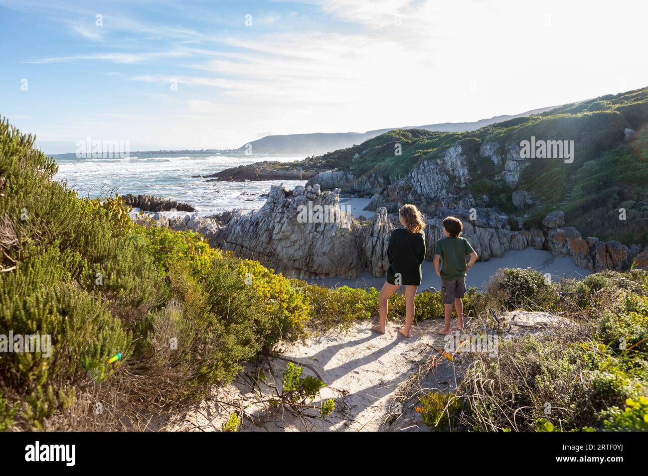 Sudafrica, Hermanus, fratello (10-11) e sorella (16-17) che guardano l'Oceano Atlantico a Voelklip Beach Foto Stock