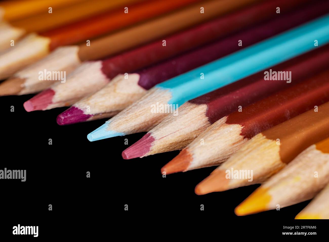 Fila di matite di colore marrone con una matita blu allineata l'una all'altra Foto Stock