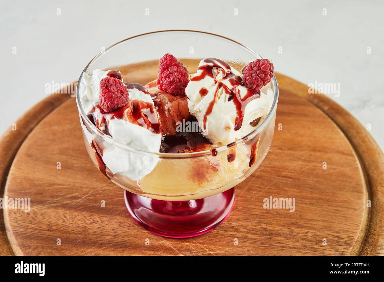 Pesche con lamponi, gelato alla vaniglia, marmellata di frutta e mandorle Foto Stock