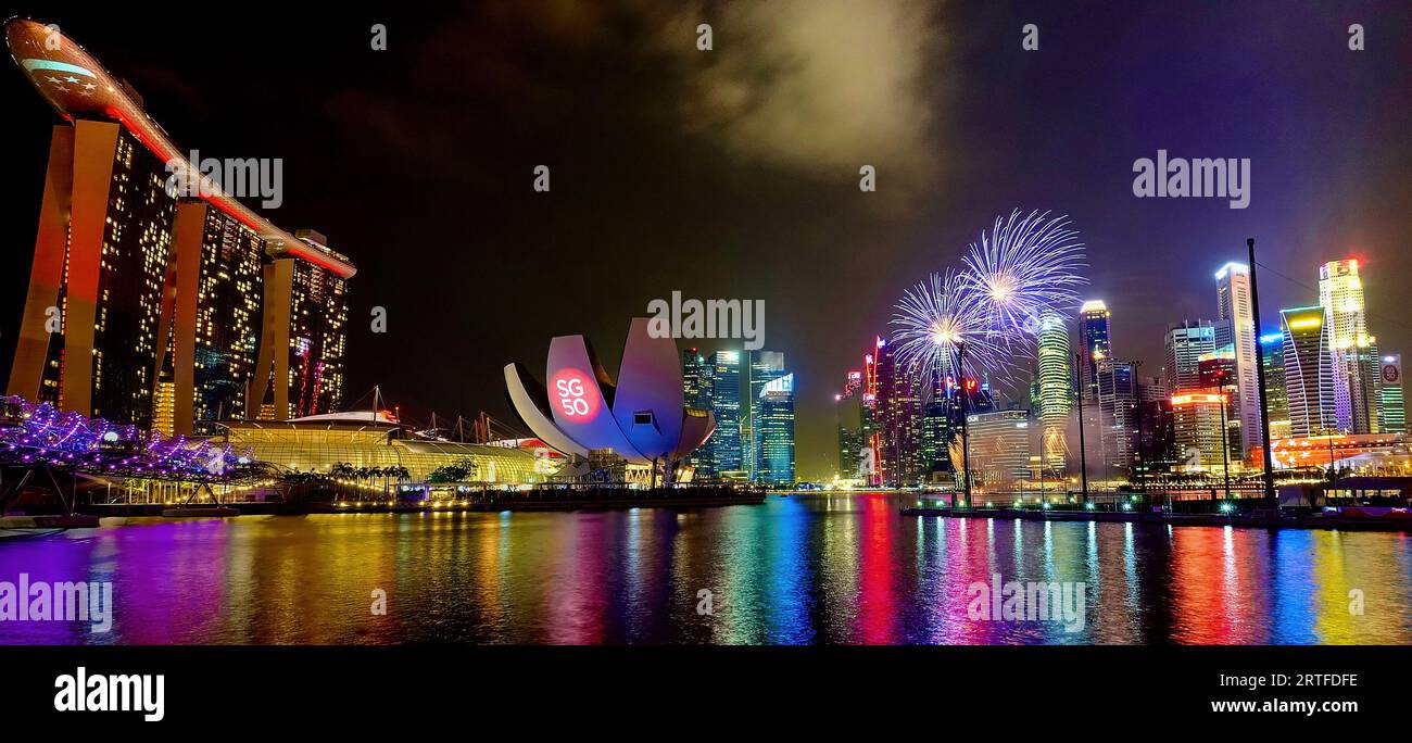 Fuochi d'artificio su Marina Bay, Singapore, mentre Singapore celebra il suo 50° anniversario il giorno Nazionale del 15/8/2015; sinistra: L'iconico Marina Bay Sands Hotel Foto Stock