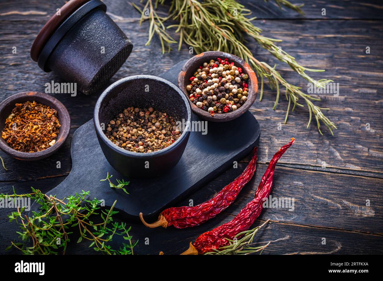 Tritatutto per spezie in ghisa per pepe, sale ed erbe aromatiche con ingredienti Foto Stock