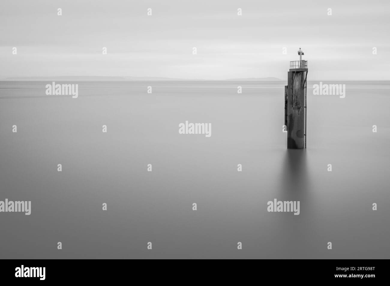 Moody, bianco e nero lunga esposizione, di un singolo, vecchio palo di legno, nell'oceano. Spazio per la copia. Foto Stock