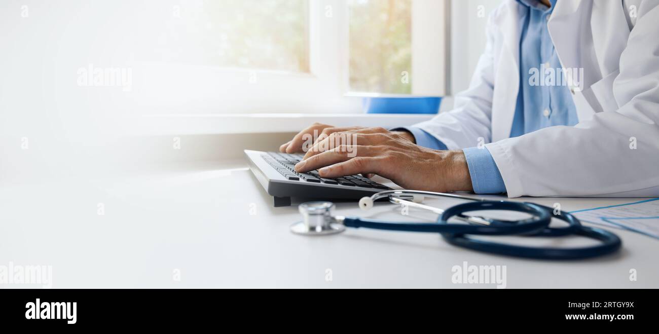 medico che digita sulla tastiera del computer. lavorare in uno studio ospedaliero. consulenza medica online, comunicazione e concetto di ehealth. striscione con spazio per la copia Foto Stock