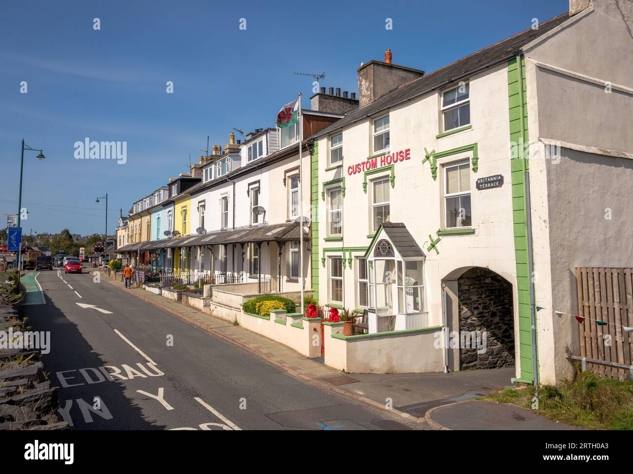 Fila di alloggi terrazzati color pastello sulla strada principale a Portmadoc, Gwynedd, Galles. Foto Stock