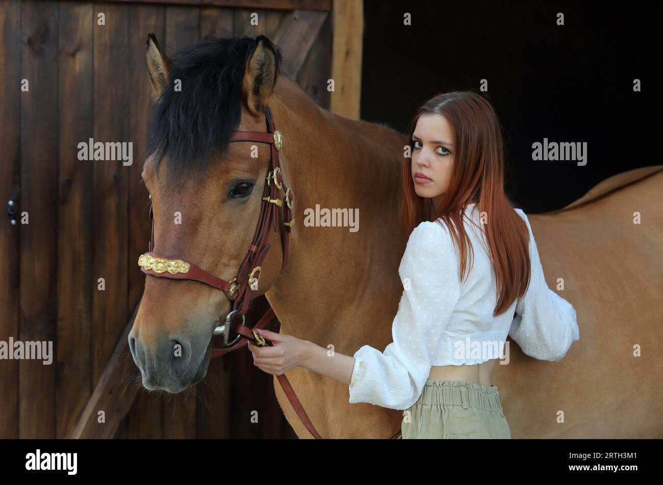 Bella ragazza di campagna in posa con il cavallo nel ranch Foto Stock