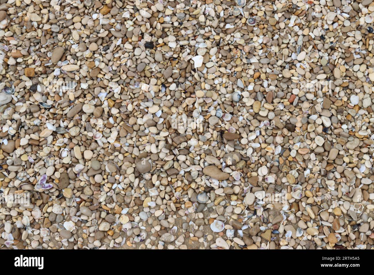 Un letto in ghiaia con un mix di rocce marroni, bianche e nere Foto Stock