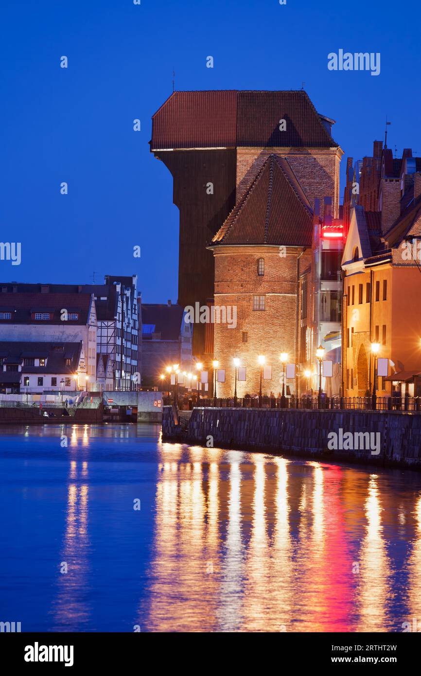 La Gru illuminata di notte a Danzica, Polonia, simbolo della città, un punto di riferimento del XV secolo e architettura di fiume Motlawa waterfront Foto Stock
