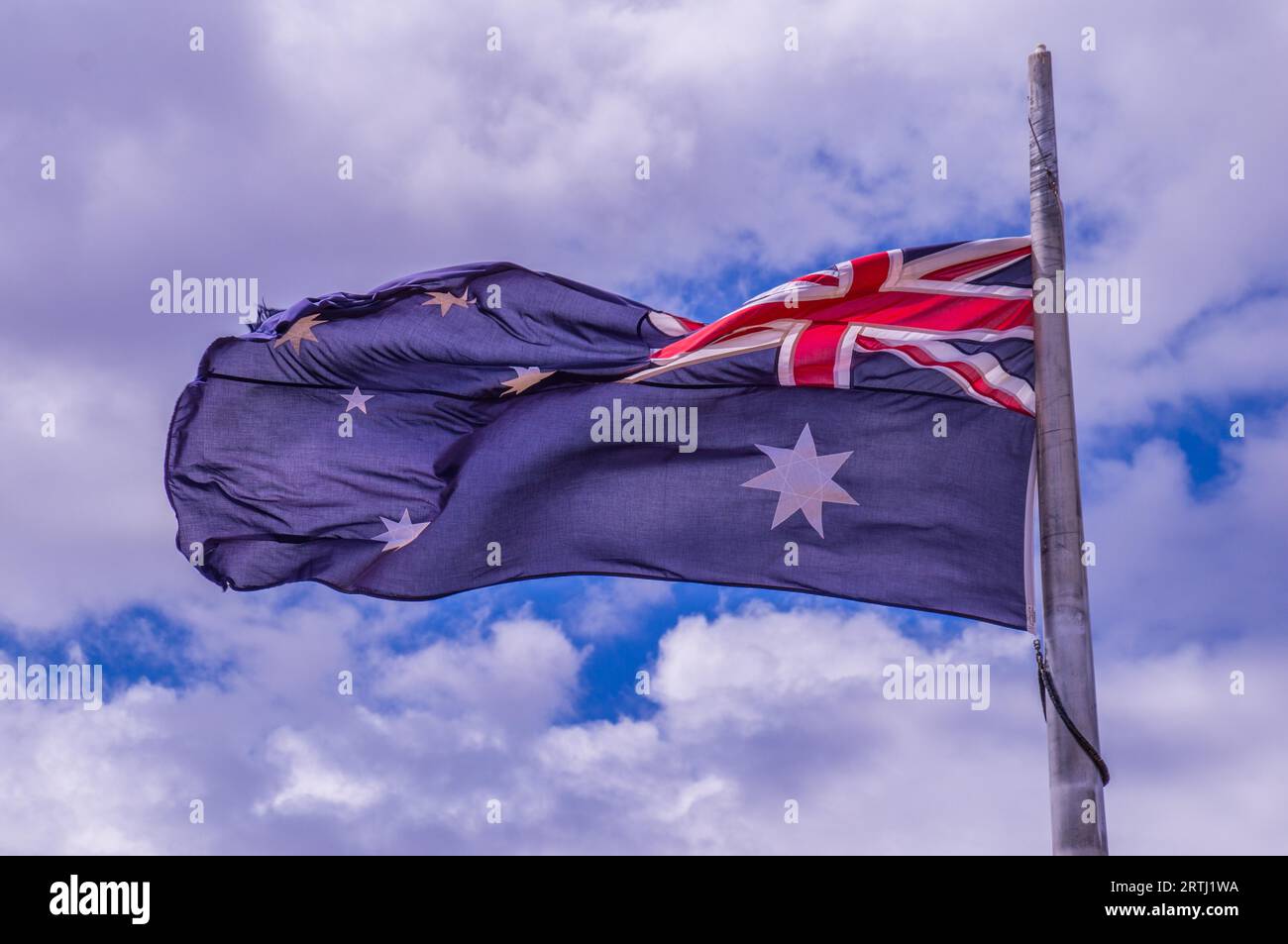 Svolazzanti bandiera australiana con cielo azzurro sfondo nel vento Foto Stock