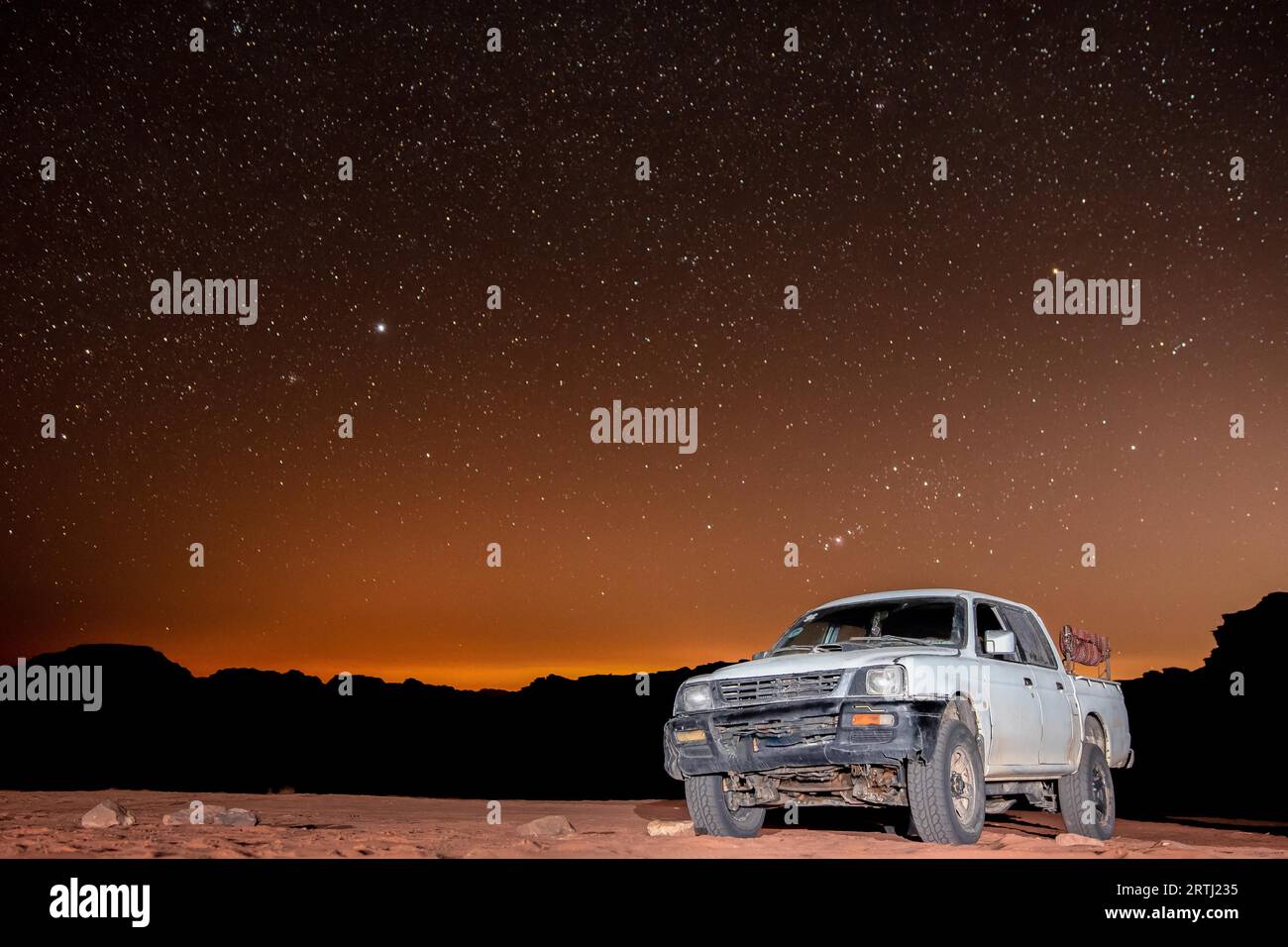 Osservazione delle stelle nel deserto di Wadi Rum in Giordania. Dozzine di campi Beduin offrono tour in camion e alloggi turistici nel deserto sotto il cielo sereno Foto Stock