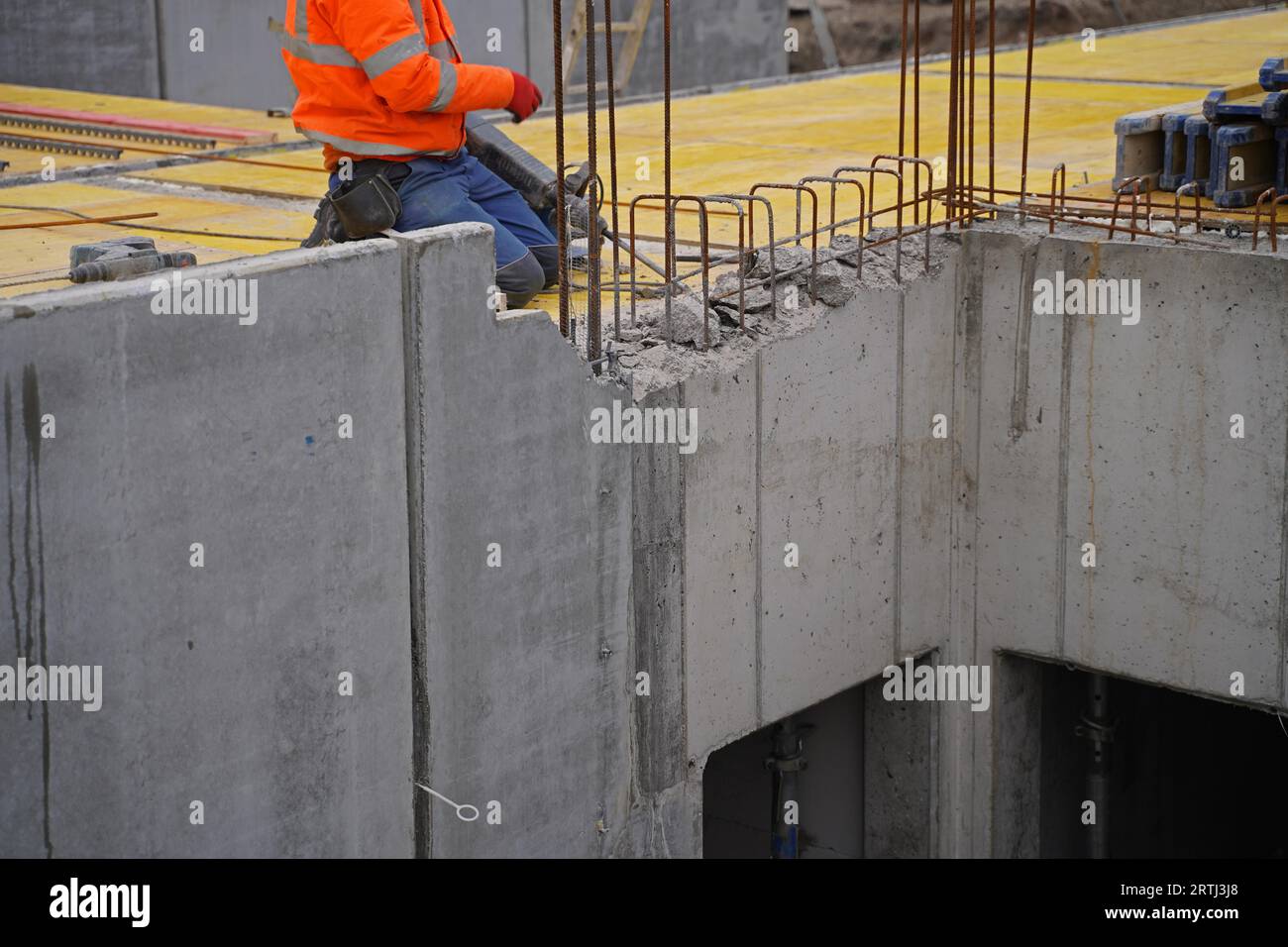 Costruzione di abitazioni in un grande cantiere con gru a braccio a reticolo per la costruzione di nuovi edifici residenziali Foto Stock