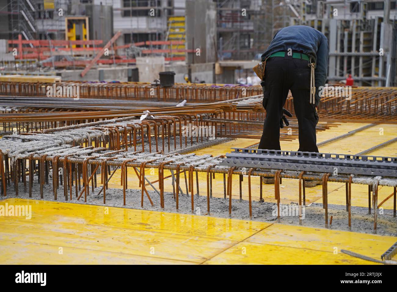 Costruzione di abitazioni in un grande cantiere con gru a braccio a reticolo per la costruzione di nuovi edifici residenziali Foto Stock