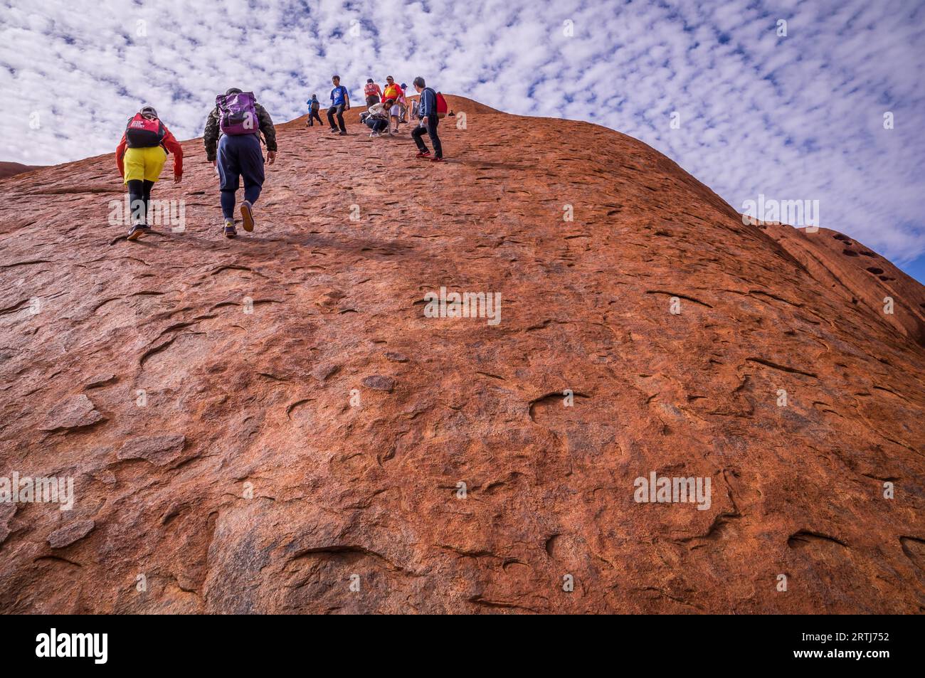 Uluru Ayers Rock, Australia l'11 settembre 2015: I turisti si arrampicano su e giù per Uluru. Gli aborigeni Anangu di Uluru chiedono alla gente di rispettare Foto Stock