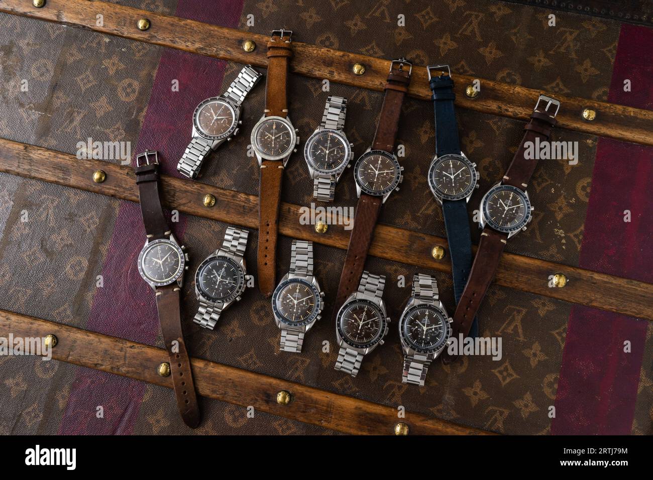 Riprese vintage Omega Speedmaster su una vecchia custodia da viaggio Louis Vuitton rivettata con il suo iconico motivo LV. Foto Stock