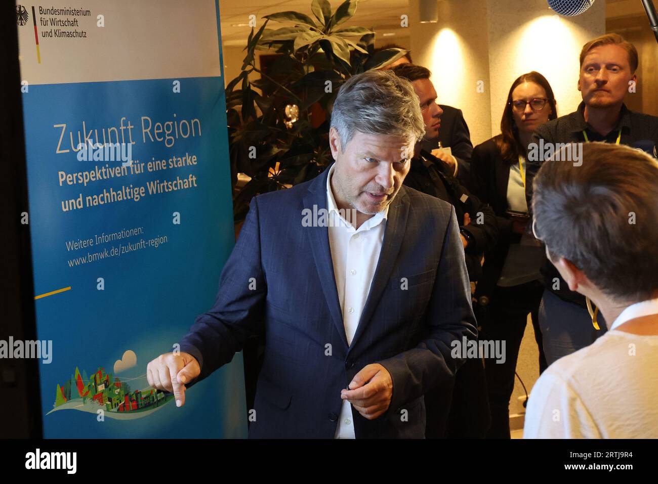 Rostock, Germania. 13 settembre 2023. Alla prima conferenza annuale "Shaping Regional Transformation", Robert Habeck (Verdi), ministro federale dell'economia, parla con Claudia Ellgoth di Altentreptow alla mostra "Future Region". Il Ministero federale dell'economia ha invitato alla conferenza nel municipio. In futuro, la conferenza, che si terrà ogni anno in un altro stato federale, affronterà i prossimi processi di cambiamento dovuti, ad esempio, al cambiamento climatico, allo sviluppo demografico e alla trasformazione digitale. Crediti: Bernd Wüstneck/dpa/Alamy Live News Foto Stock