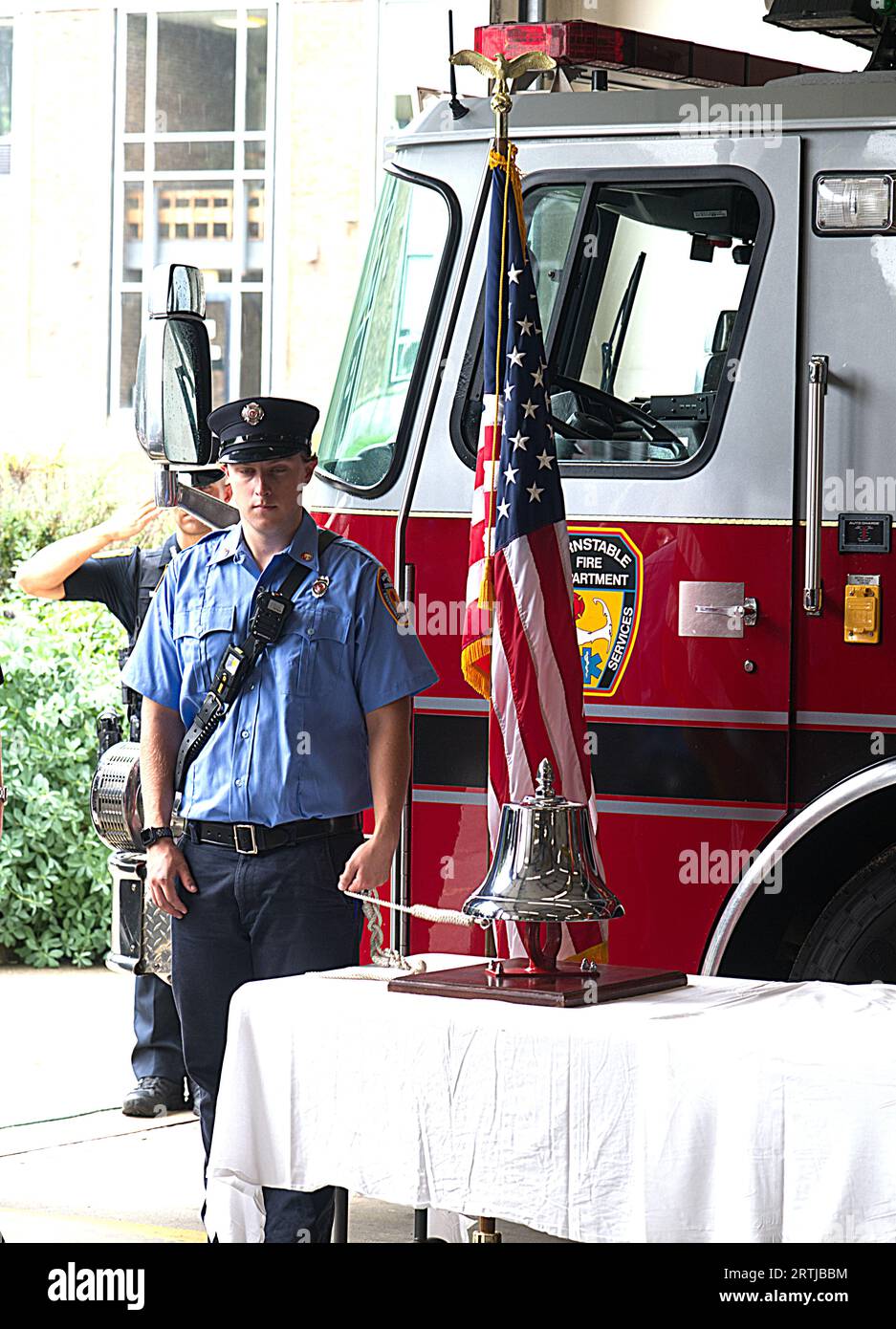 911 cerimonia di commemorazione presso la sede centrale dei vigili del fuoco di Barnstable, Massachusetts, a Cape Cod, Stati Uniti. Un vigile del fuoco suona la campana in memoria di coloro che sono morti il 911 Foto Stock