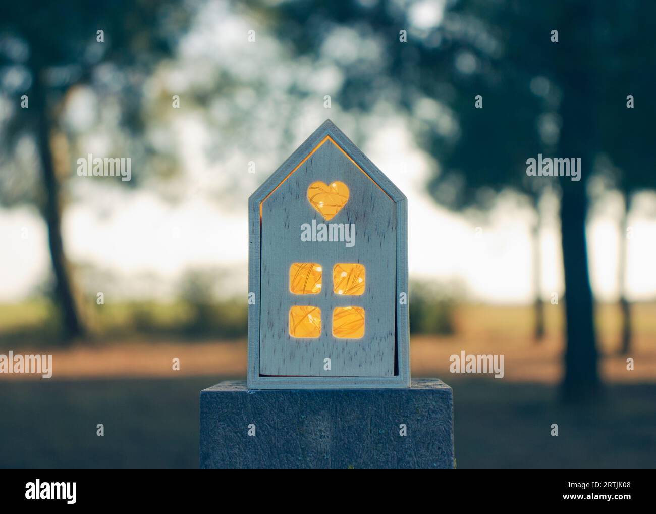 Una cattura di un'intima cabina in legno illuminata internamente sullo sfondo naturale durante l'incantevole ora d'oro del tramonto. Foto Stock