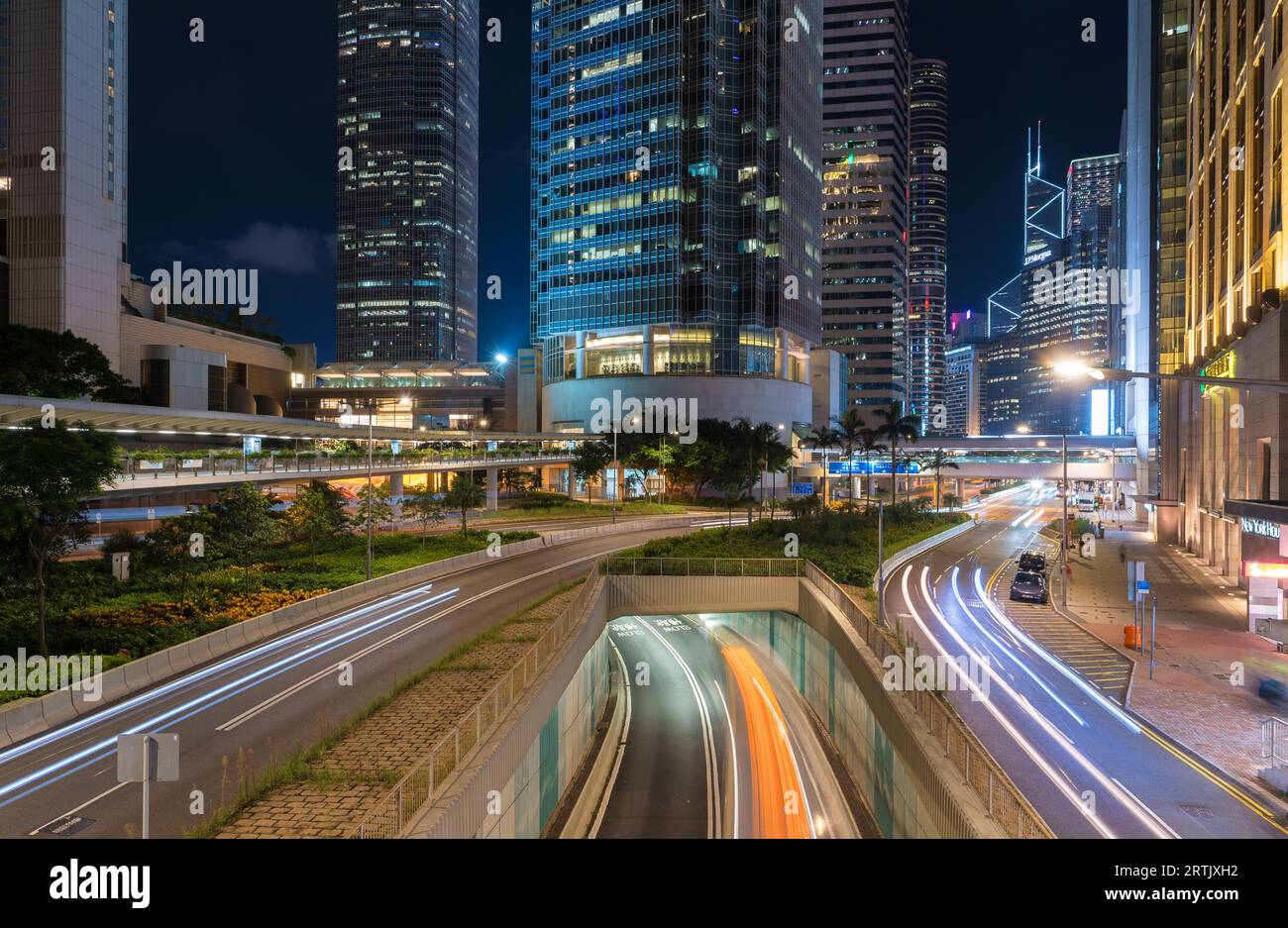 Connaught Road è uno scalo centrale a Hong Kong di notte ai piedi di un International Finance Centre. Con strisce leggere di auto in movimento Foto Stock