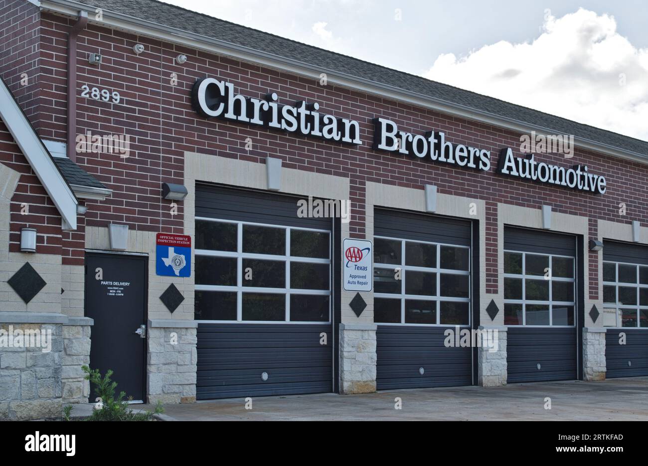 Houston, Texas USA 07-30-2023: Christian Brothers Automotive officina esterna e porte di garage a Houston, Texas. Stima della catena aziendale di riparazione automatica. 1982. Foto Stock
