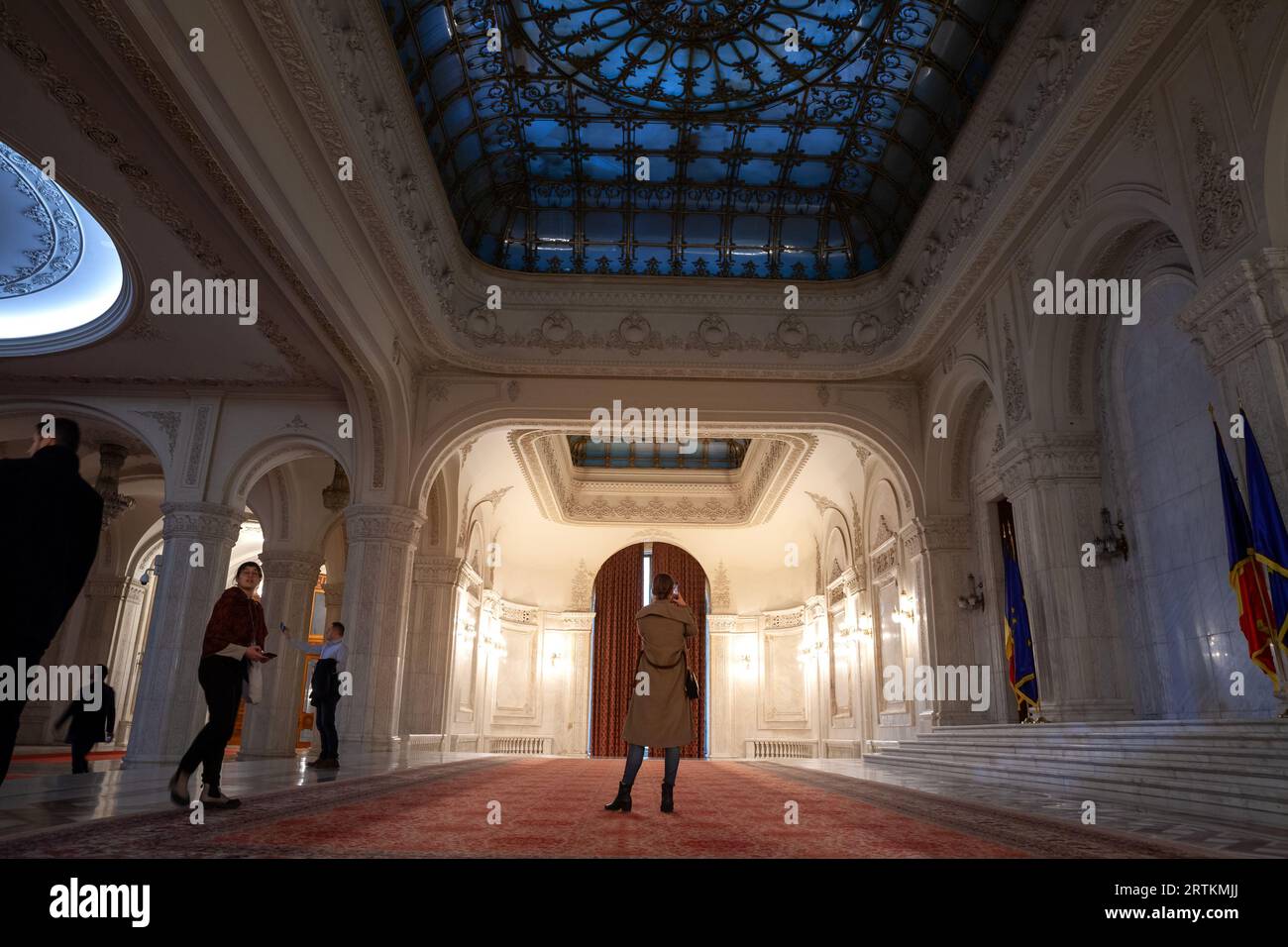 Foto dell'interno del palazzo del parlamento rumeno, con un turista che scatta foto di una sala di ricevimento. Il Palazzo del Parlamento, Foto Stock