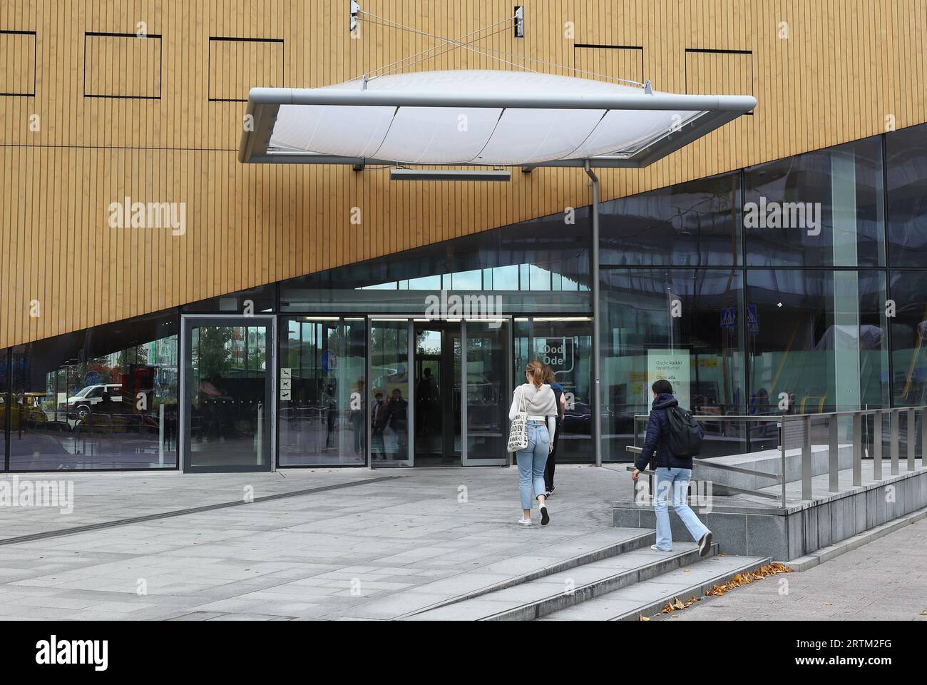Helsinki, Finlandia - 5 settembre 2023: I visitatori camminano verso l'ingresso della biblioteca centrale di Helsinki Oodi. Foto Stock
