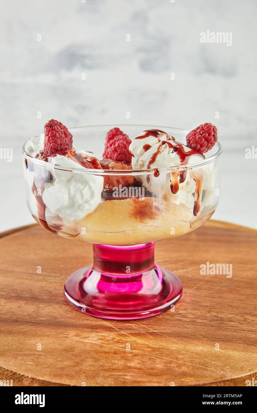 Pesche con lamponi, gelato alla vaniglia, marmellata di frutta e mandorle Foto Stock