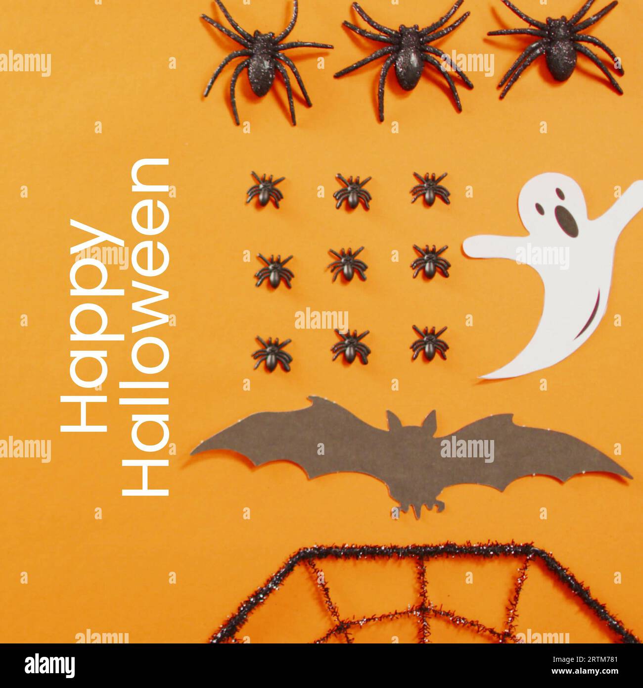 Testo felice di halloween con fantasmi, pipistrelli e insetti su sfondo arancione Foto Stock