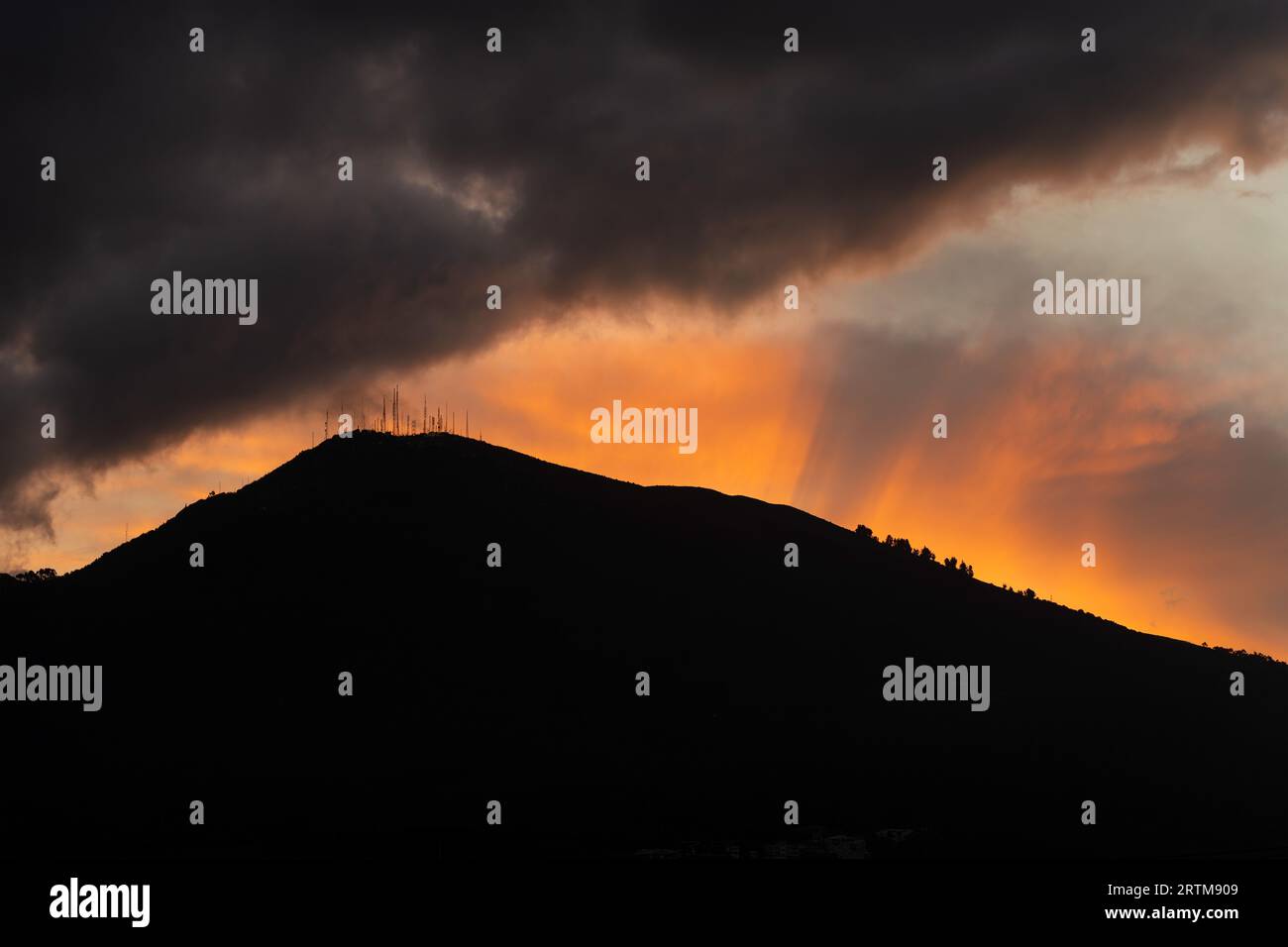 Il tramonto del sole e le nuvole di temporale sopra il vulcano Pichincha, Quito, Ecuador. Foto Stock