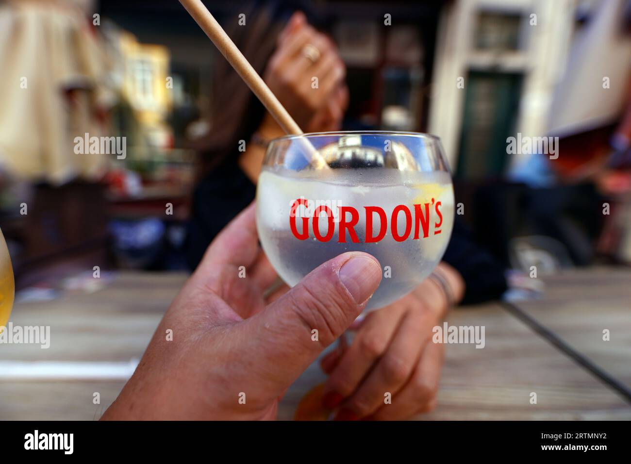 Uomo seduto in estate sulla terrazza con un cocktail in mano. Porto. Portogallo. Foto Stock