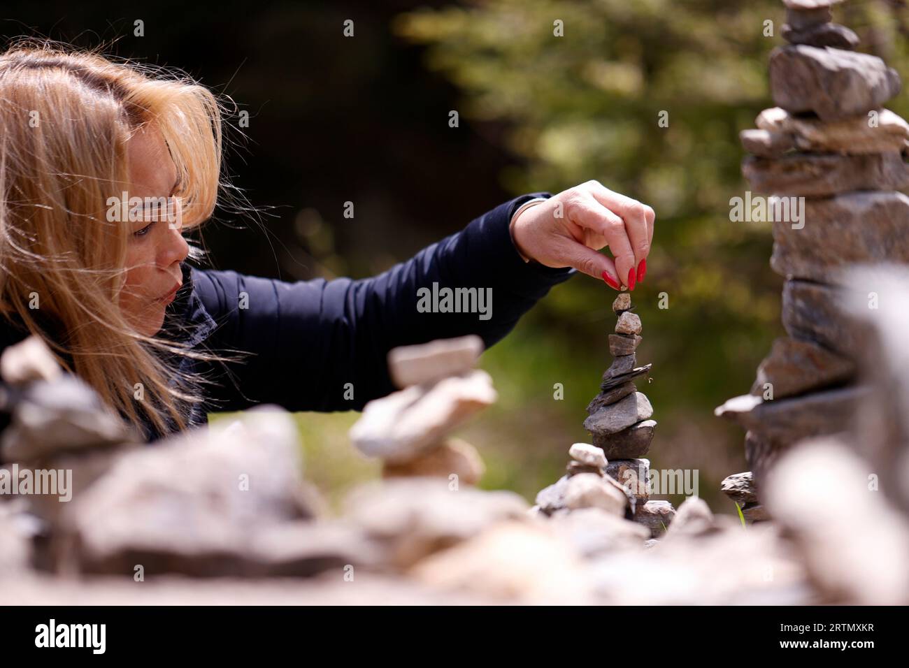 Primo piano sul cairn, sulla piramide in pietra, sul sentiero di montagna c'è un cartello con la memoria turistica. Foto Stock