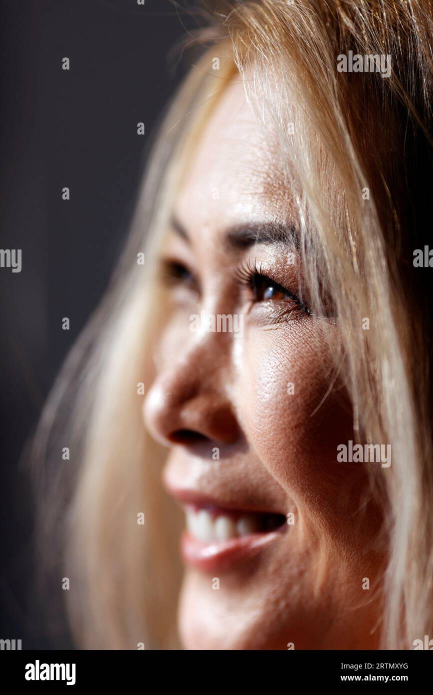 Ritratto di bella donna asiatica con lunghi capelli biondi e trucco. Foto Stock
