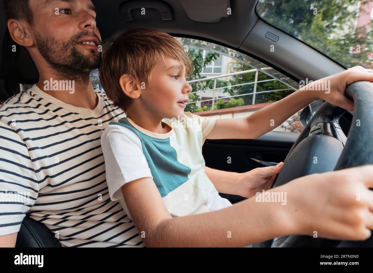 Il Figlio Può Guidare L Auto Del Padre Padre con figlio piccolo in grembo immagini e fotografie stock ad alta