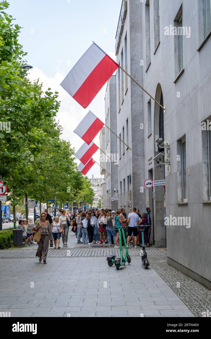 Persone in fila. Bandiere della Polonia per strada. National Polish Bank NBP, Narodowy Bank Polski. Money Center. Sede centrale di Centrum Pieniadza. Polonia, Varsavia - 27 luglio 2023. Foto Stock