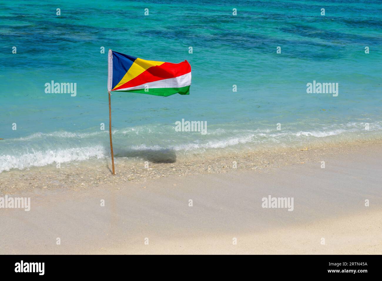 Bandiera delle Seychelles, spiaggia di sabbia bianca e fondo d'acqua turchese con spazio per le copie Foto Stock