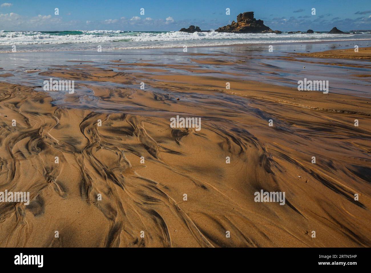 Spiaggia sabbiosa con bassa marea in Algarve, Portogallo Foto Stock