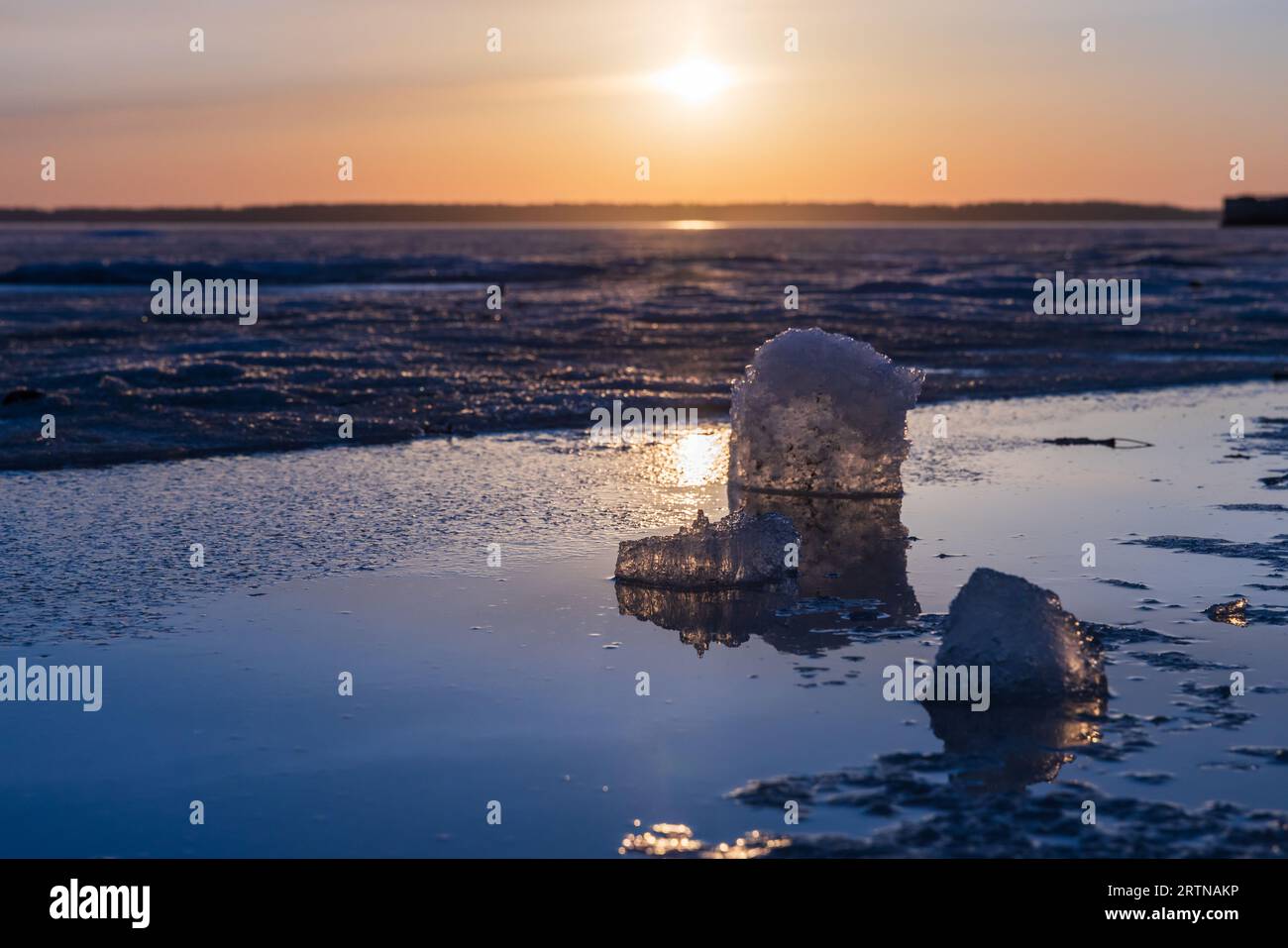 Paesaggio invernale con lago ghiacciato. I cubetti di ghiaccio sono esposti alla luce del sole al tramonto, foto ravvicinate della natura Foto Stock